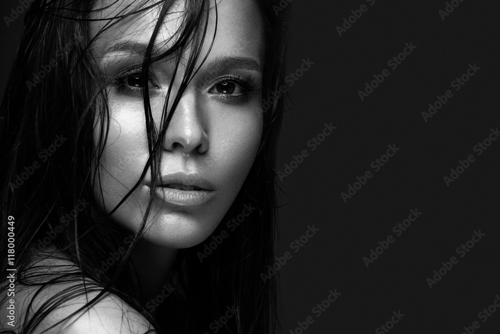 Beautiful girl with a bright make-up and wet hair and skin. Beauty face. Black and white photo. Picture taken in the studio on a black background. Beautiful girl with a bright make-up and wet hair and skin. Beauty face. Black and white photo. Picture taken in the studio on a black background.