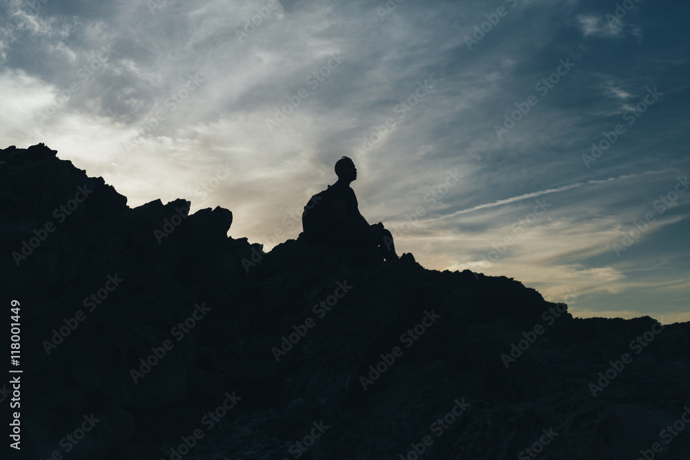 Back light silhouette of a man standing on a hill, overlooking