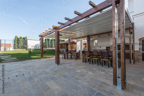Long table and chairs on veranda in luxury villa exterior