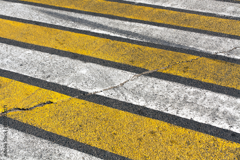 Fototapeta premium Old damaged white and yellow zebra pedestrian crossing.