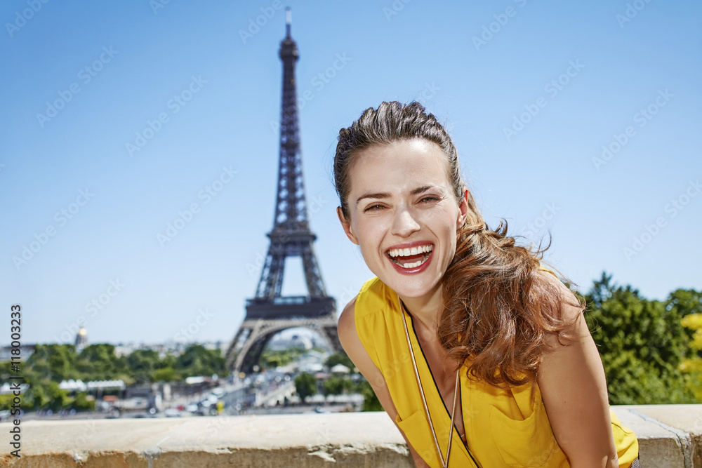 smiling young woman in bright blouse against Eiffel tower, Paris