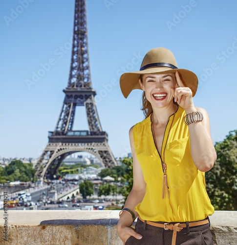 smiling young woman in bright blouse against Eiffel tower, Paris © Alliance