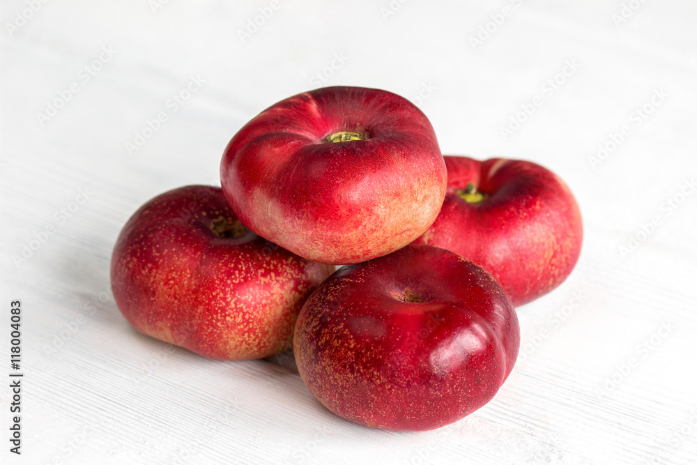 Fresh flat peach fruits on white wooden table Fresh flat peach fruits on white wooden table