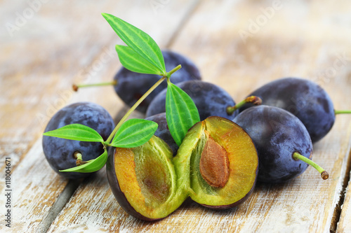 Few juicy plums on rustic wooden surface, closeup
