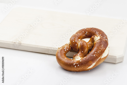 Eine Laugenbrezel liegt auf einem Holzbrett photo