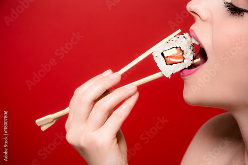 A girl eating a sushi roll.