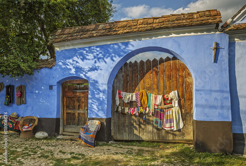 Wooden gate of a traditional Saxon dwelling in Viscri village, a landmark of Romania. Handmade fabric artifacts exposed on the exterior walls.