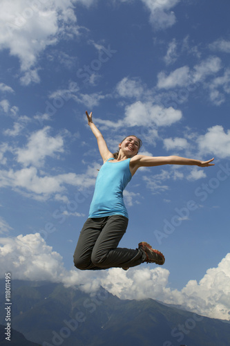 young happiness woman is jumping against blue sky. summer sunny day