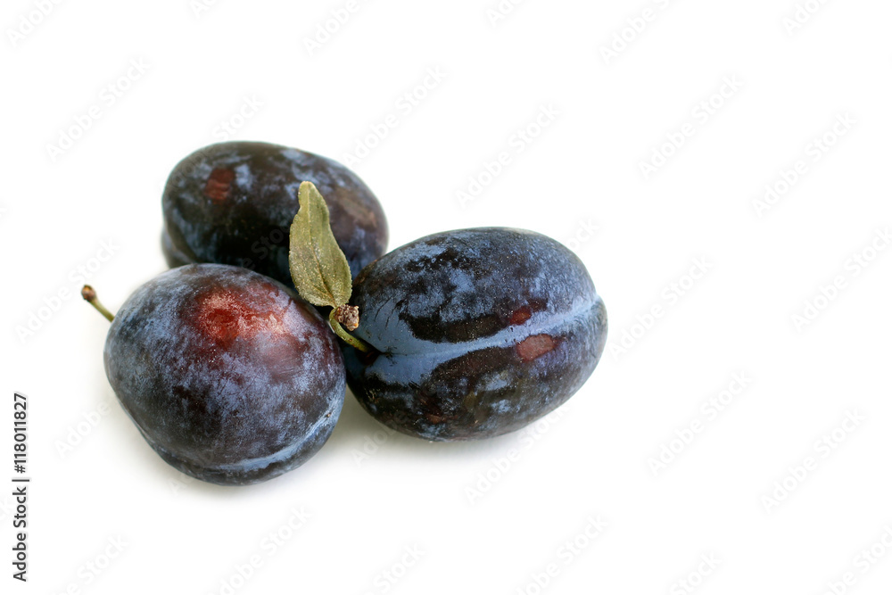 Obraz premium Plums with leaves on white background