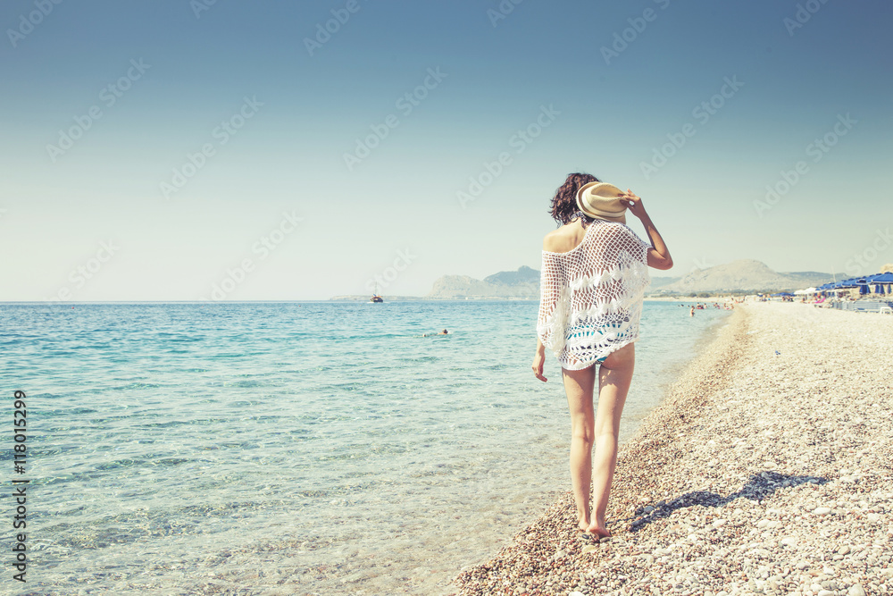 Beautiful girl bathed in sunshine walking on the beach Beautiful girl bathed in sunshine walking on the beach