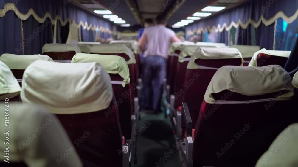 Interior of intercity long distance coach passengers boarding a bus at night station terminal shallow depth of field Interior of intercity long distance coach passengers boarding a bus at night station terminal shallow depth of field