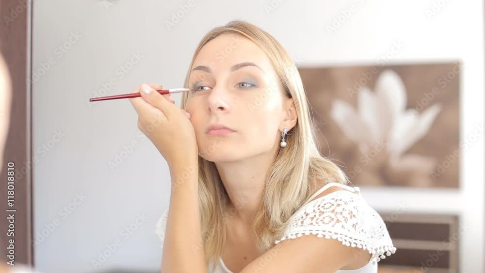 Beauty woman applying makeup. Beautiful girl looking in the mirror Beauty woman applying makeup. Beautiful girl looking in the mirror