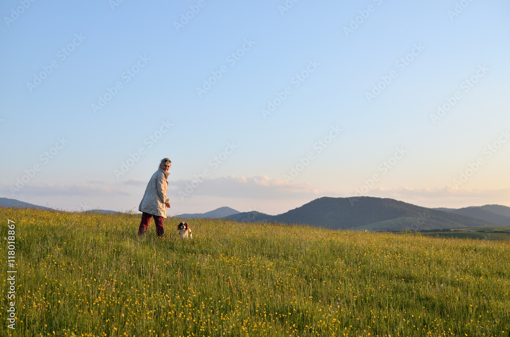 Woman with her Cavalier King Charles Spaniel Blenheim dog in a wonderful mountain landscape Woman with her Cavalier King Charles Spaniel Blenheim dog in a wonderful mountain landscape