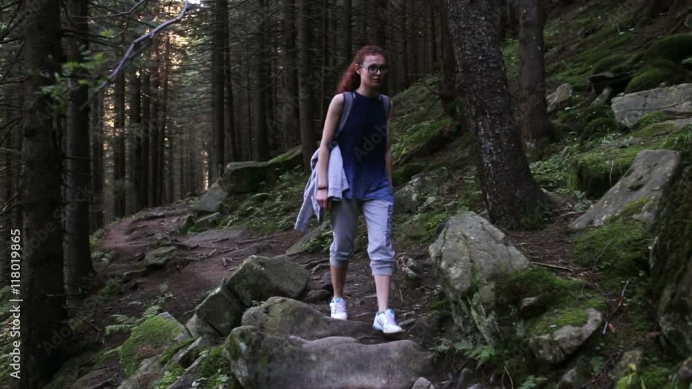 Woman traveler is walking through the mountains and forests Woman traveler is walking through the mountains and forests