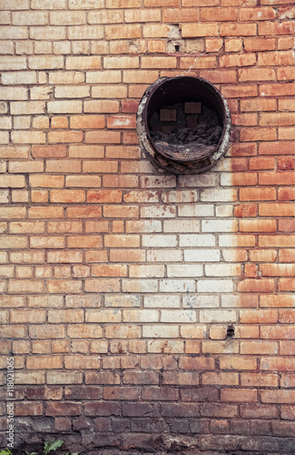 brick wall with a piece of old steel pipe