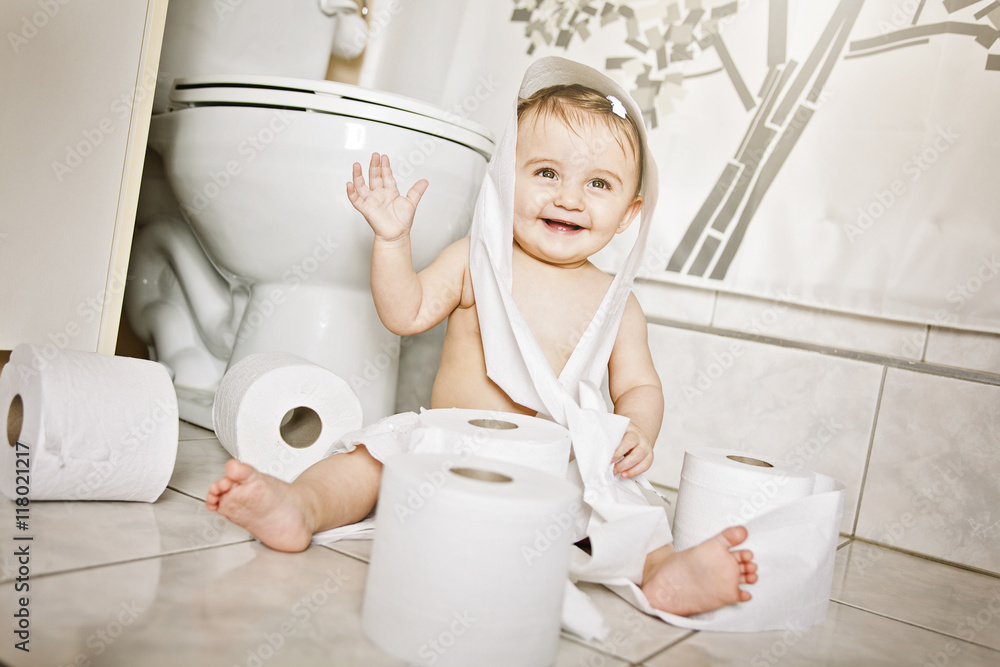 Toddler ripping up toilet paper in bathroom Toddler ripping up toilet paper in bathroom