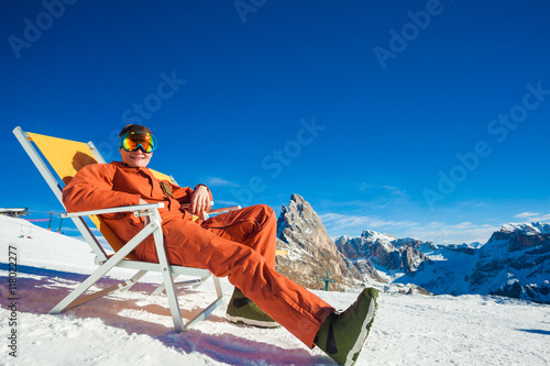 Bild auf Leinwand Snowboarder on top of the mountain sitting on chair chaise lounge
