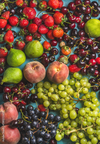 Fototapeta Naklejka Na Ścianę i Meble -  Healthy summer fruit variety. Black and green grapes, strawberries, figs, sweet cherries and peaches, top view, vertical