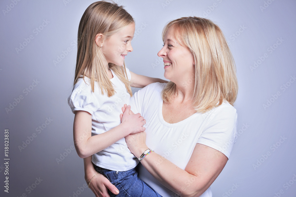 A mother with is daughter over gray background A mother with is daughter over gray background