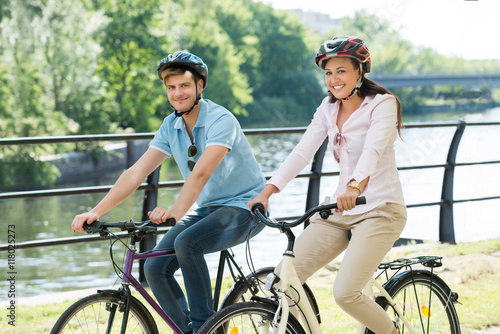 Couple On Bicycles Ride In The Park