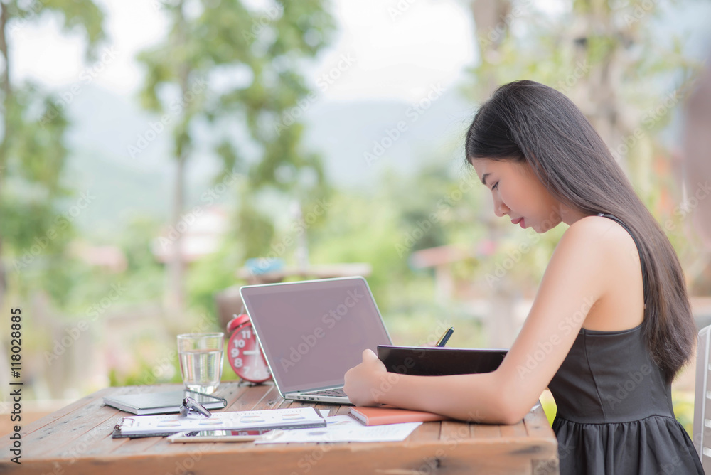 Young woman wearing smartwatch using laptop computer. Female wor Young woman wearing smartwatch using laptop computer. Female wor