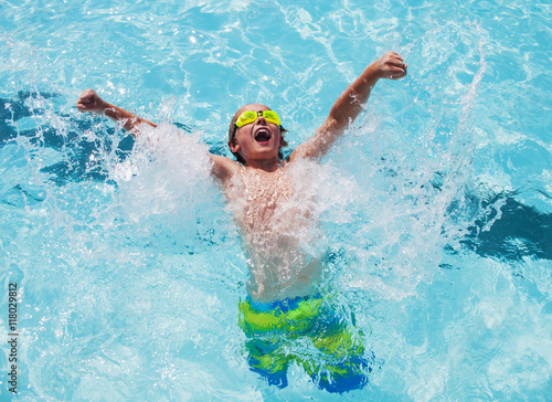 Cheerful boy in goggles in swimming pool 