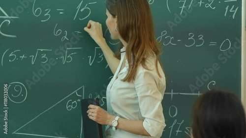 Teacher Doing Math on Chalkboard