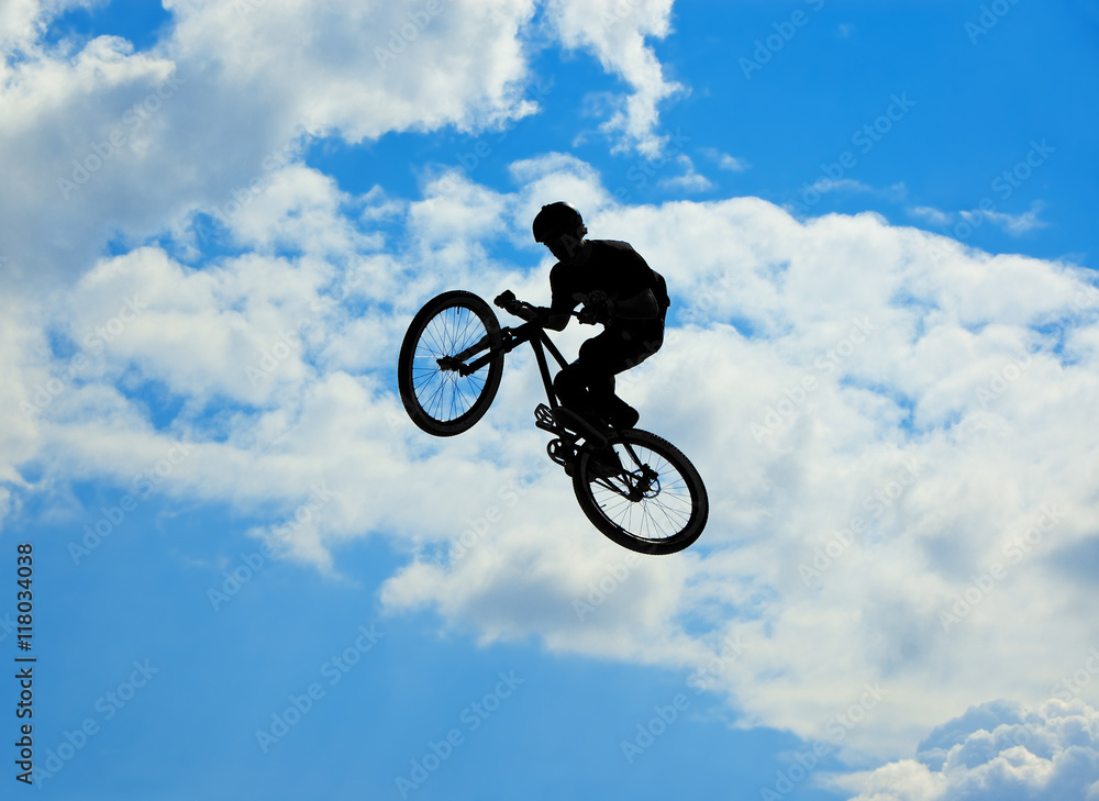 Silhouette image of a cyclist on the background of sky and clouds Silhouette image of a cyclist on the background of sky and clouds