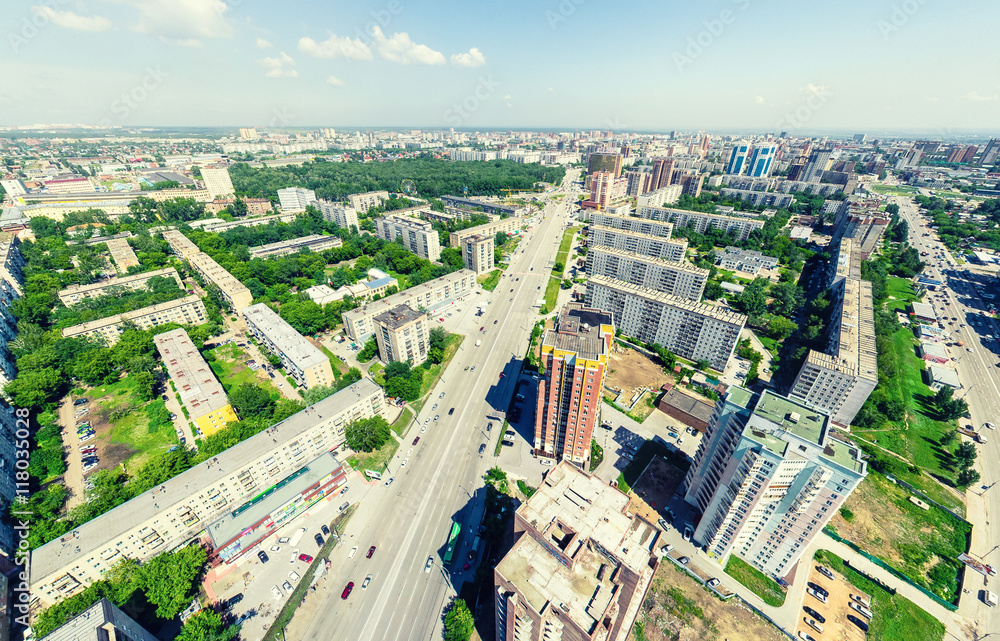 Fototapeta premium Aerial city view with crossroads and roads, houses, buildings, parks and parking lots, bridges. Urban landscape. Copter shot. Panoramic image.