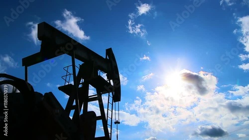 Oil pump machine working over bright blue sky.