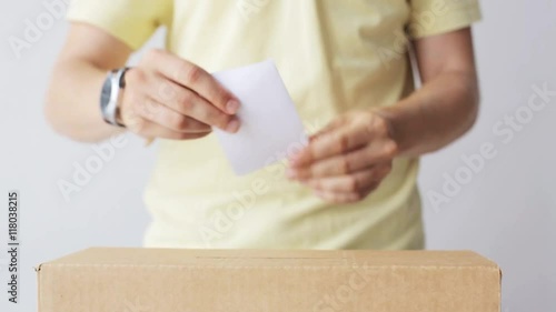 man putting his vote into ballot box on election