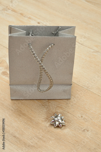 A silver gift bag with a bow