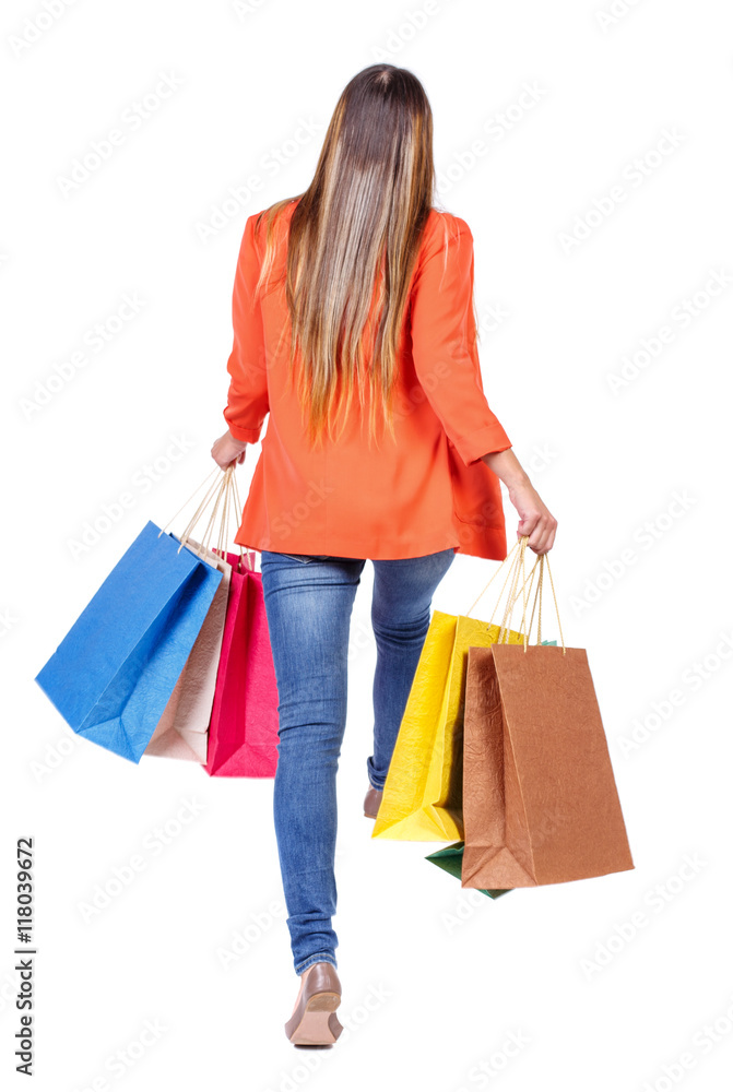 back view of a woman jumping with shopping bags. beautiful brunette girl in motion.  backside view of person.  Rear view people collection. Isolated over white background. girl in a red jacket jumping