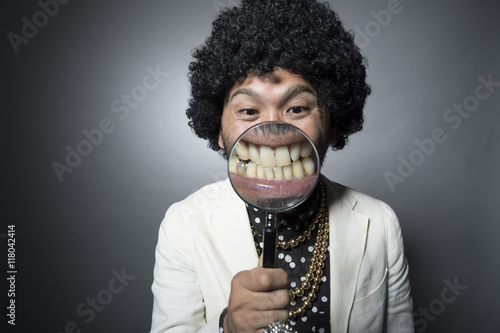 Men who are expanding the teeth with magnifying glass