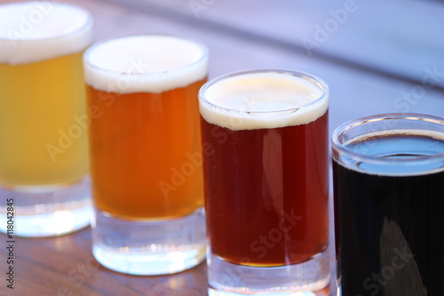 A selection of four different craft beers on a wooden board
