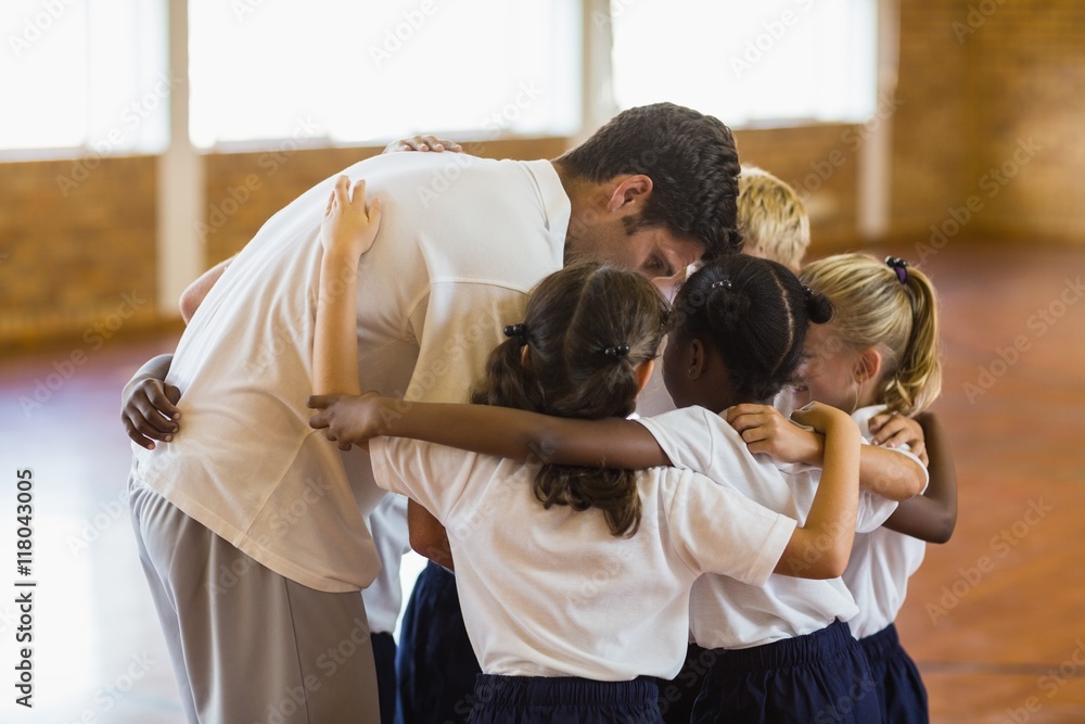 Naklejka premium Sport teacher and students forming a huddle