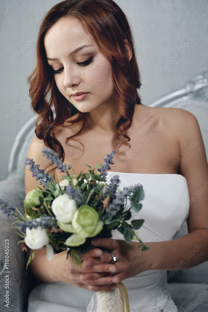 Portrait of the beautiful bride against a window indoors