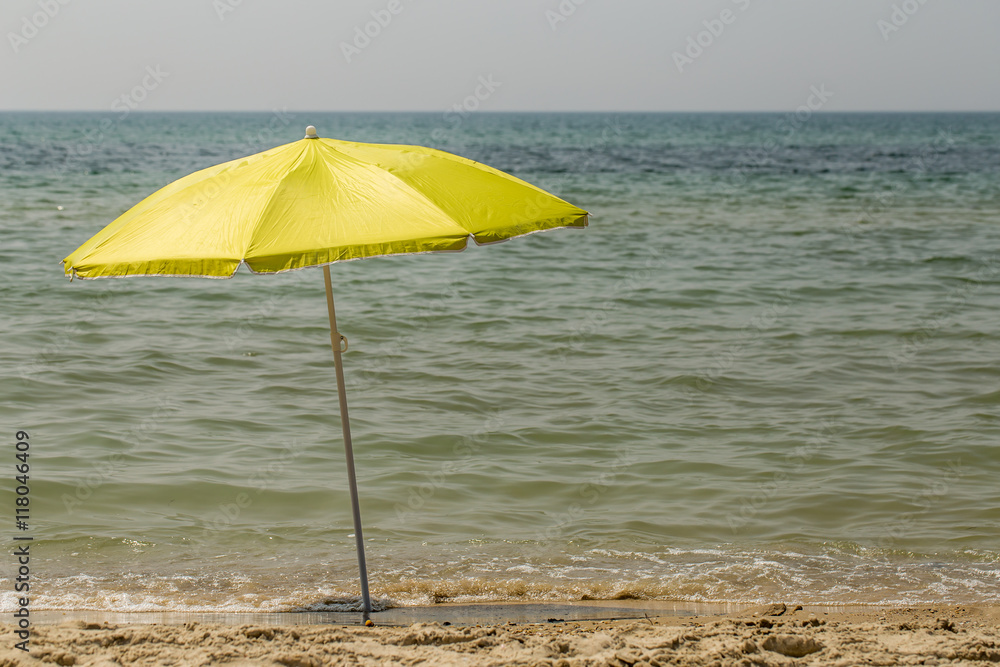 Yellow beach umbrella, sea background