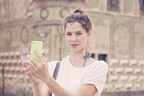 Young woman with her smart phone taking pictures. photo