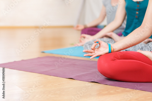 Three woman relaxing in lotus asana with hands gesturing Zen