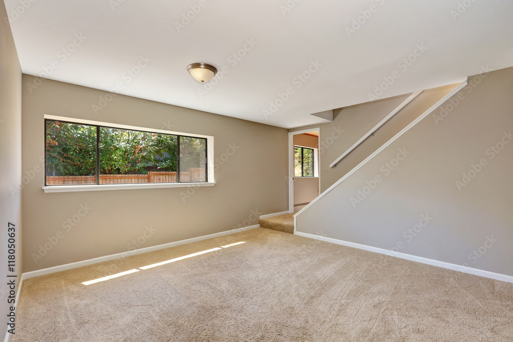 Fototapeta premium Empty beige room with staircase and carpet floor.