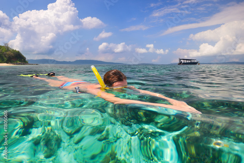 Woman snorkeling in clear tropical waters on a background of islands © soft_light