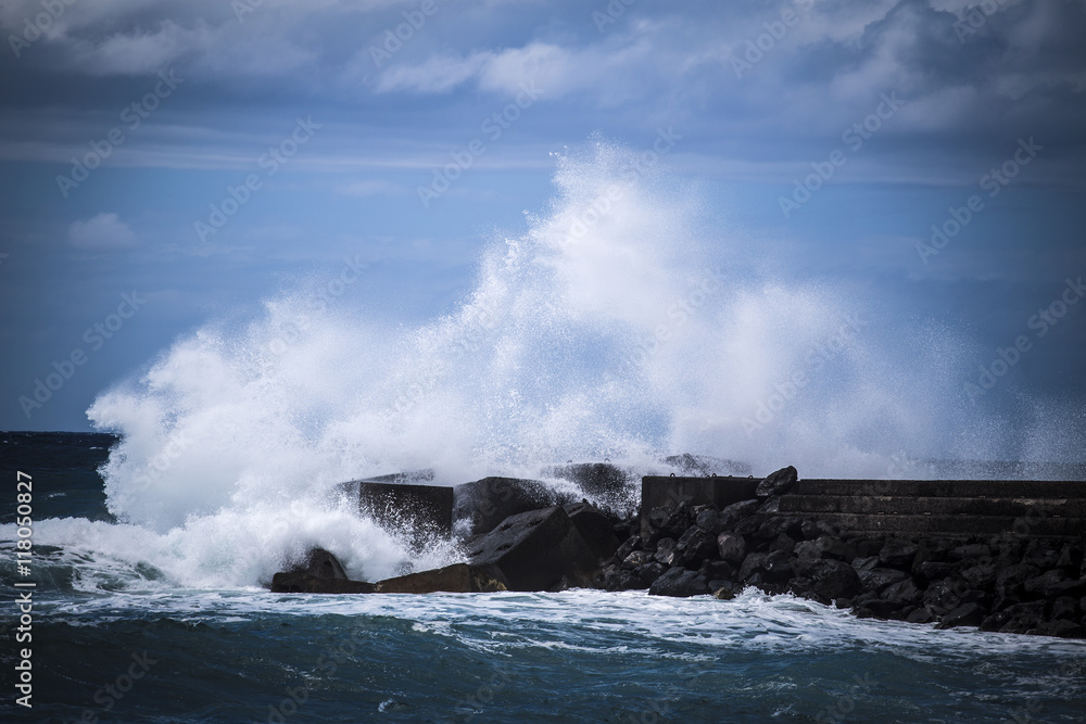 Stone breakwater with breaking waves.
