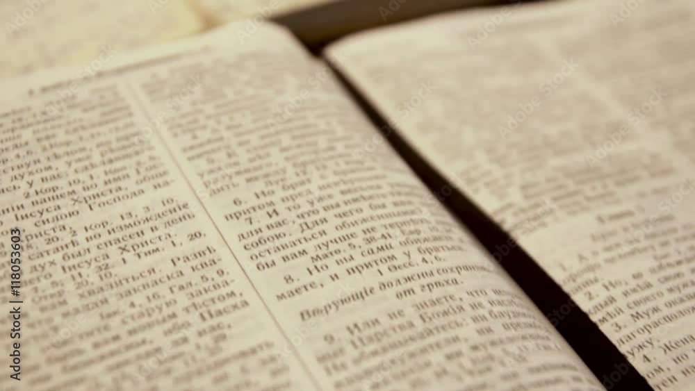Camera flying over open Bible on Russian language Camera flying over open Bible on Russian language