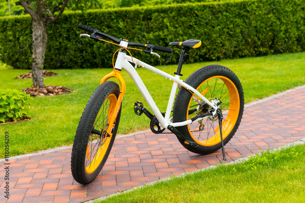 Orange modern sport bicycle parked on a footpath