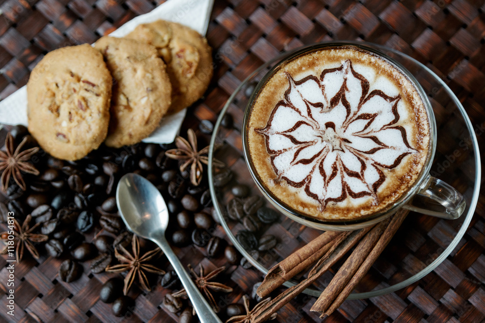 A cup of cafe latte with coffee beans and cookies A cup of cafe latte with coffee beans and cookies