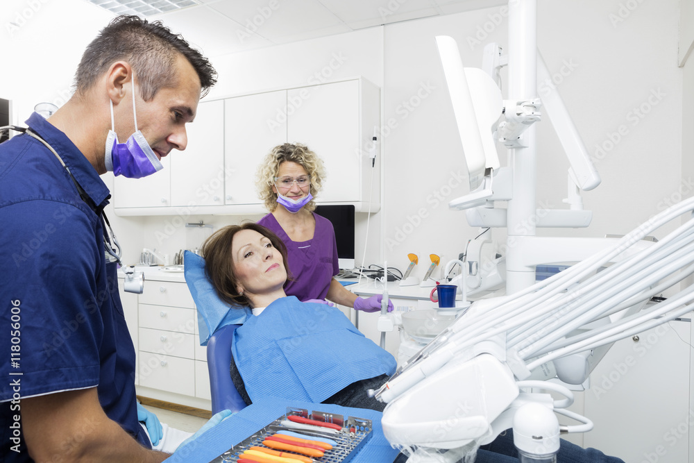 Doctor And Assistant Examining Patient At Dentistry Doctor And Assistant Examining Patient At Dentistry