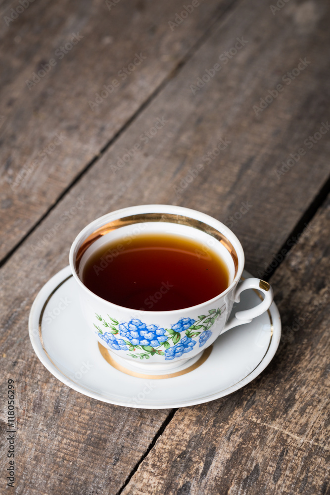Closeup of cup of tea on vintage wooden background