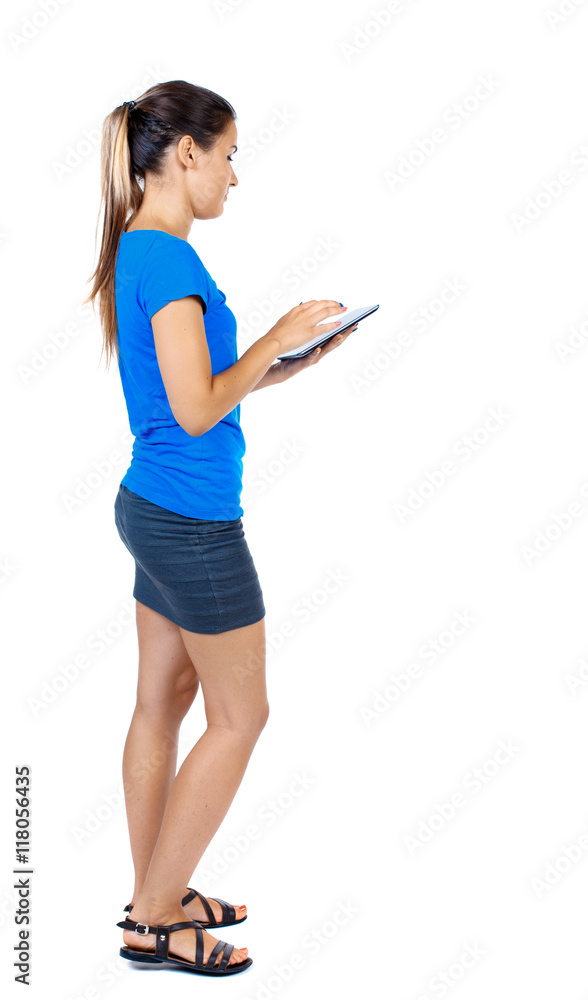 back view of standing young beautiful woman using a mobile phone or tablet computer. girl watching. Rear view people collection. backside view of person. Isolated over white background. girl in a back view of standing young beautiful woman using a mobile phone or tablet computer. girl watching. Rear view people collection. backside view of person. Isolated over white background. girl in a