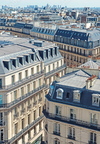 Paris rooftops. Beautiful view of the rooftops of Paris on a sunny day. Traditional parisian architecture, buildings with mansards and roofs with chimneys